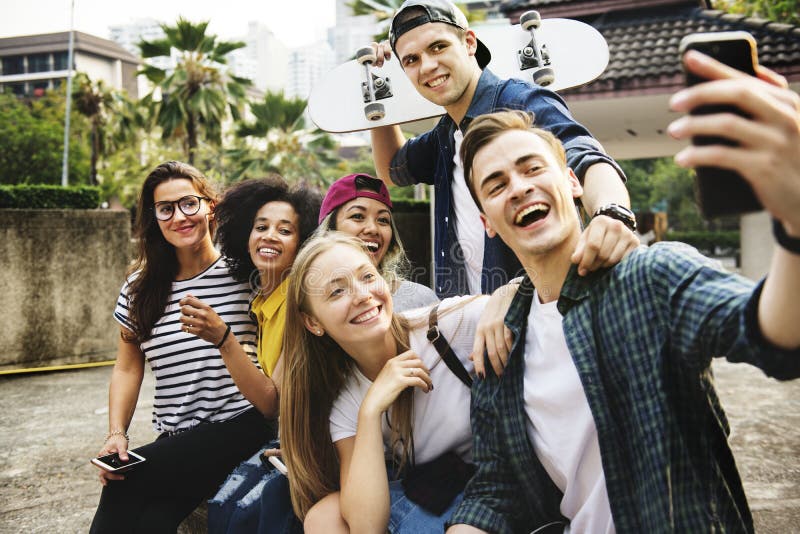 Friends in the park taking a group selfie millennial and youth culture concept. Friends in the park taking a group selfie millennial and youth culture concept