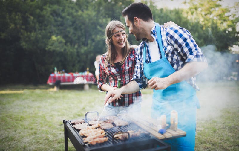 Amis heureux appréciant la partie de barbecue photo stock Amis heureux appréciant la partie de barbecue photo stock