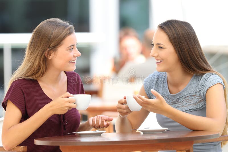 Two happy friends having a good conversation sitting in a bar terrace. Two happy friends having a good conversation sitting in a bar terrace