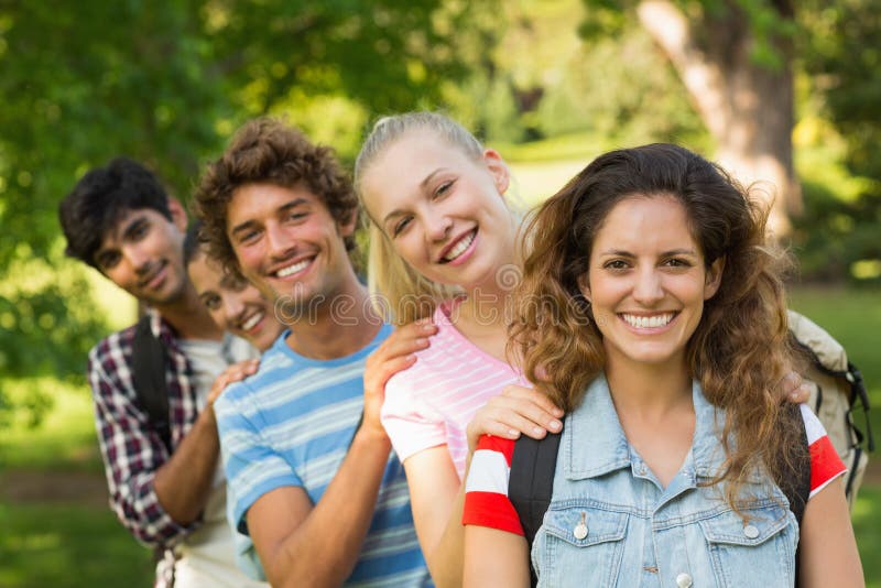 Group portrait of happy college friends standing in a row at the campus. Group portrait of happy college friends standing in a row at the campus