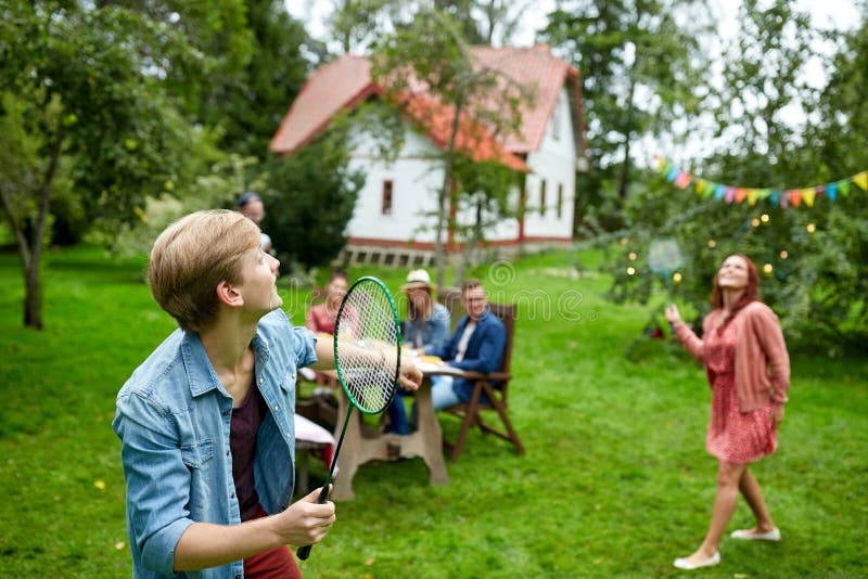 Amis heureux jouant le badminton au jardin d'été photos stock Amis heureux jouant le badminton au jardin d'été photos stock