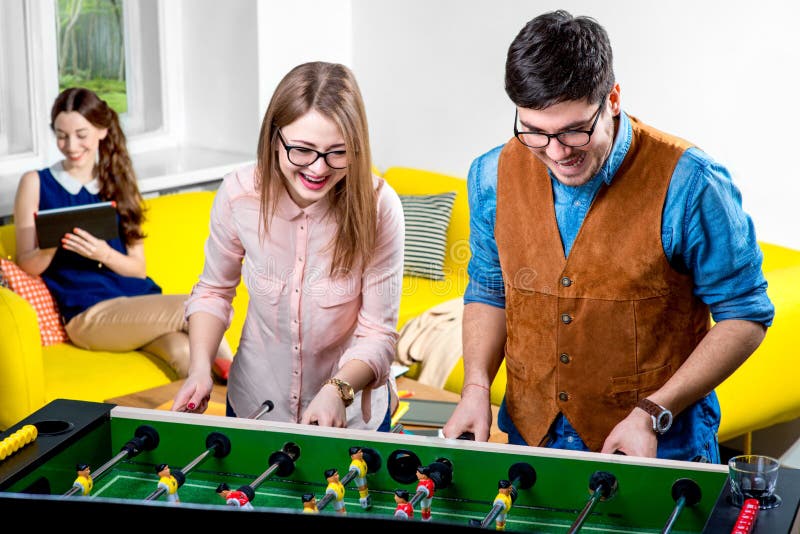 Amis jouant le football de table photo libre de droits Amis jouant le football de table photo libre de droits