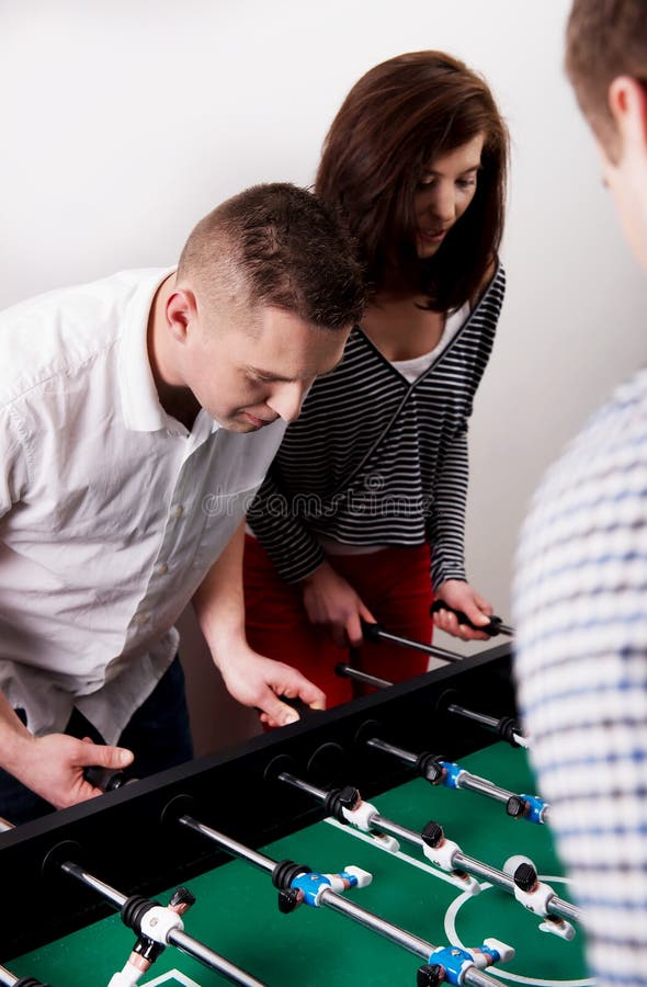 Amis jouant le football de table photo libre de droits Amis jouant le football de table photo libre de droits