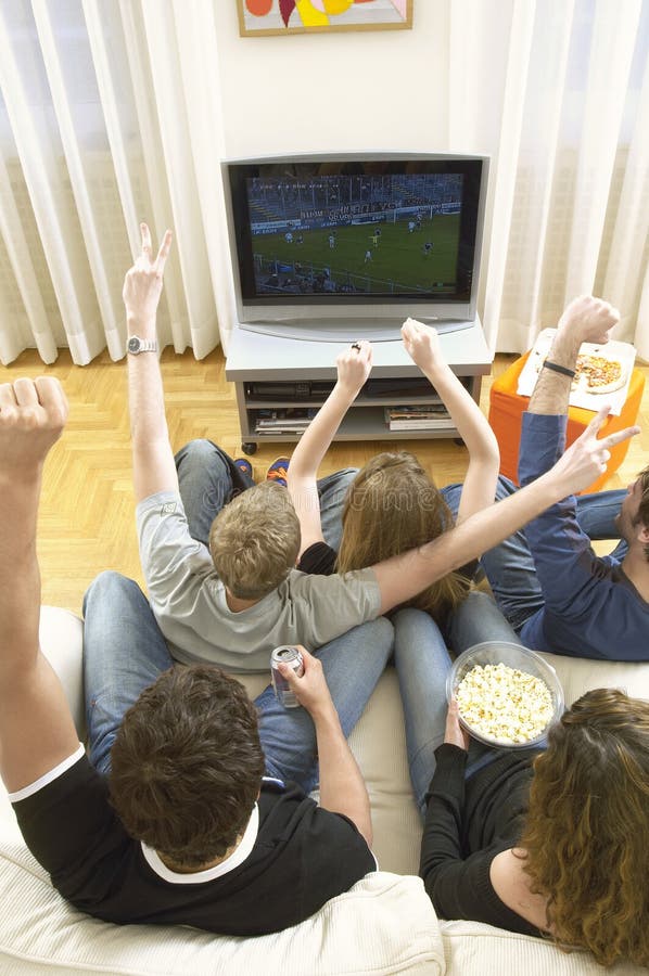 Amis observant le match de football et la célébration images libres de droits Amis observant le match de football et la célébration images libres de droits