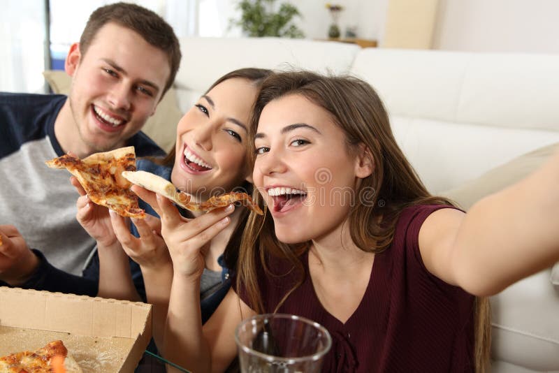 Amis prenant des selfies et mangeant de la pizza photos libres de droits