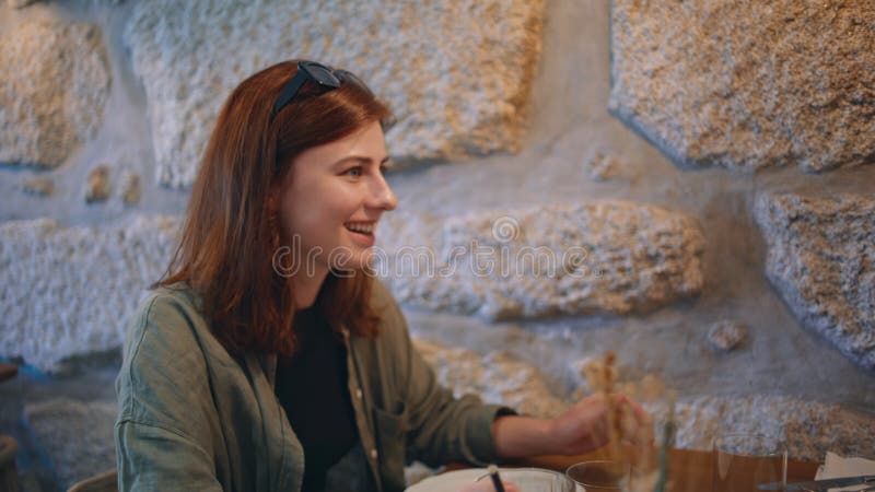 Smiling friends chatting coffeehouse under soft lamp light close up. Two friendly girls colleagues enjoy pleasant communication in cafeteria. Couple women talking at cafe table having lunch together. Smiling friends chatting coffeehouse under soft lamp light close up. Two friendly girls colleagues enjoy pleasant communication in cafeteria. Couple women talking at cafe table having lunch together.