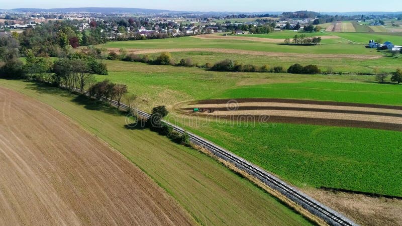 Amish farm workers organically fertilizing there fields as seen by a drone stock footage