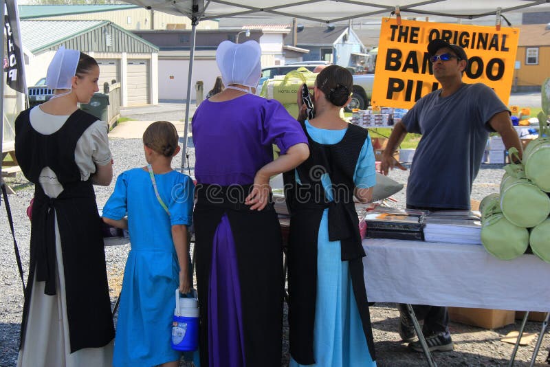 Amish rodzinna pozycja przy stołem sprawdza towary Zielonego smoka rolników rynek, Ephrata, PA, 2016 można chcieć kupować fotografia stock Amish rodzinna pozycja przy stołem sprawdza towary Zielonego smoka rolników rynek, Ephrata, PA, 2016 można chcieć kupować fotografia stock