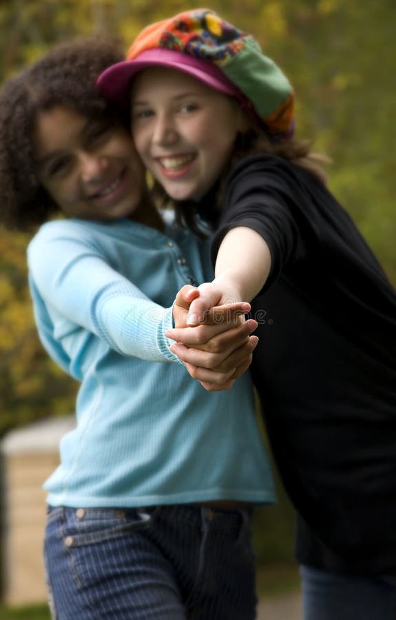 Image of two friends, onw white and one black....selective focus is just on the hands emphasizing unity. Image of two friends, onw white and one black....selective focus is just on the hands emphasizing unity