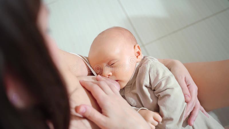Amning. ammas barn med bröstmjölk. barn somnar.