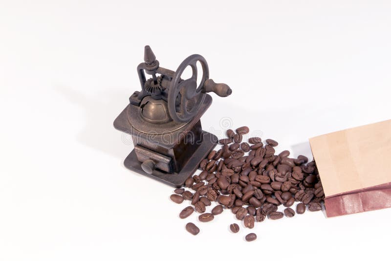 Amoladora de café de madera manual vieja con la rueda de engranaje y los granos de café dispersados imagen de archivo Amoladora de café de madera manual vieja con la rueda de engranaje y los granos de café dispersados imagen de archivo