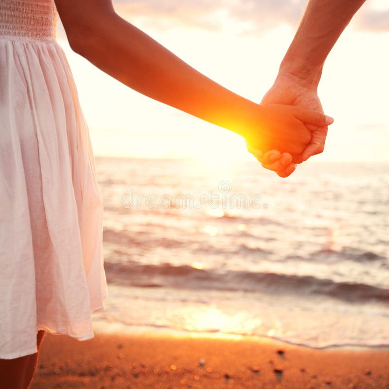 Amor - par romântico que guardara as mãos, por do sol da praia imagem de stock Amor - par romântico que guardara as mãos, por do sol da praia imagem de stock