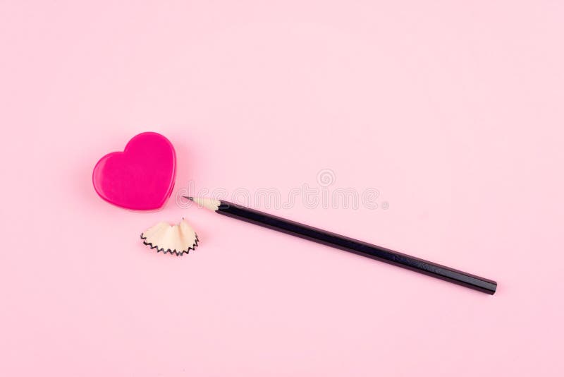 Amor, relación, concepto romántico Sacapuntas de lápiz del corazón y lápiz rosados con las virutas en fondo rosado imagenes de archivo Amor, relación, concepto romántico Sacapuntas de lápiz del corazón y lápiz rosados con las virutas en fondo rosado imagenes de archivo
