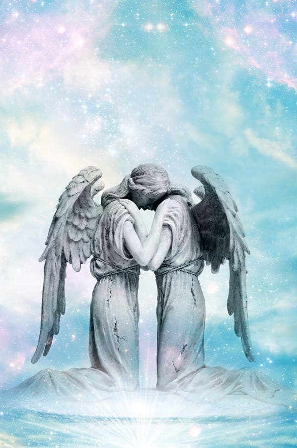 A statue of embracing angels with rays of light like a concept for angel love. A statue of embracing angels with rays of light like a concept for angel love