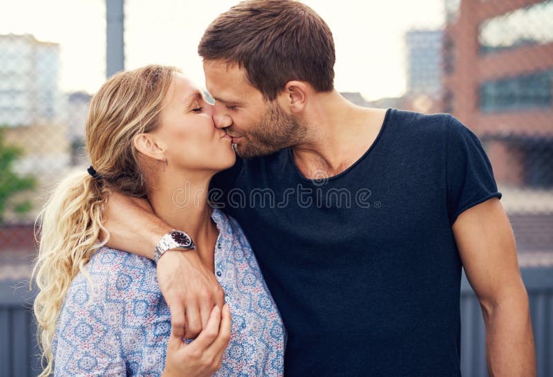 Amorous young couple enjoy a romantic kiss