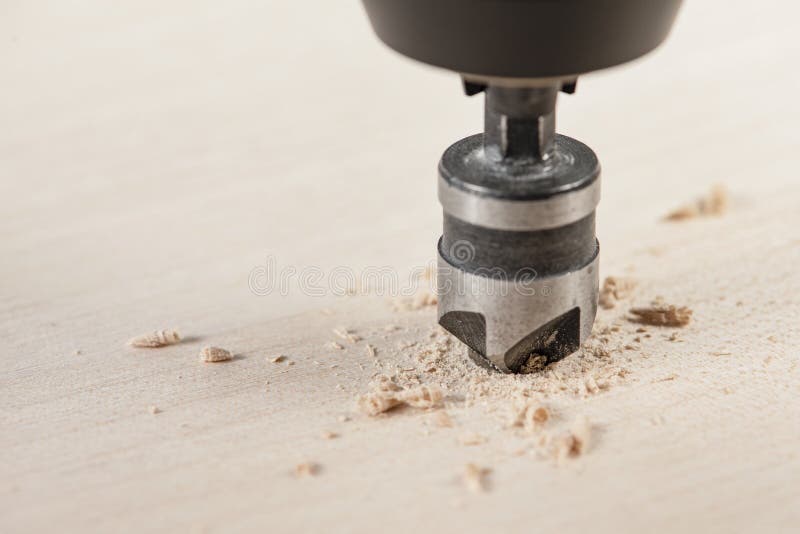 Amortiguador para profundizar el tornillo de autogolpe. un taladro de contrapeso hace un receso en un agujero para un tornillo en foto de archivo