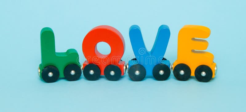 Word Love made of letters train alphabet. Bright colors of red yellow green and blue on a white background. Early childhood development, learning to read and kids game concept. Word Love made of letters train alphabet. Bright colors of red yellow green and blue on a white background. Early childhood development, learning to read and kids game concept.