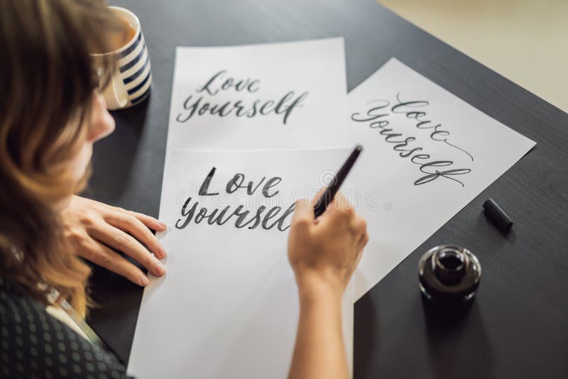 Amour vous-m?me Le calligraphe Young Woman ?crit l'expression sur le livre blanc Inscrire les lettres d?cor?es ornementales photos stock Amour vous-m?me Le calligraphe Young Woman ?crit l'expression sur le livre blanc Inscrire les lettres d?cor?es ornementales photos stock
