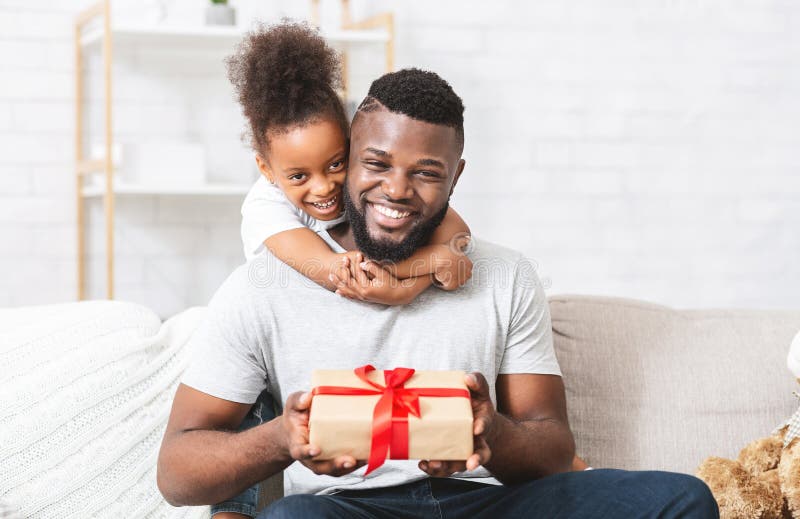 Amoureuse petite fille donnant un cadeau à son père image stock