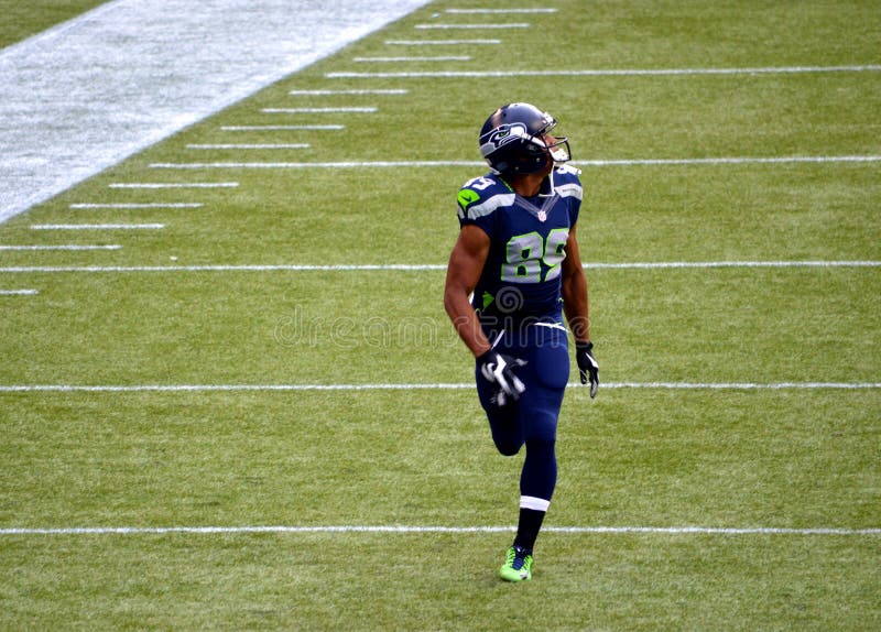 Ampio ricevitore Doug Baldwin di Seattle Seahawks che è in corsa per un passaggio fotografia stock