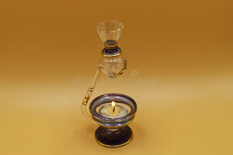 Ampolla egipcia para esencias perfumadas con velas ardientes, fondo claro foto de archivo libre de regalías