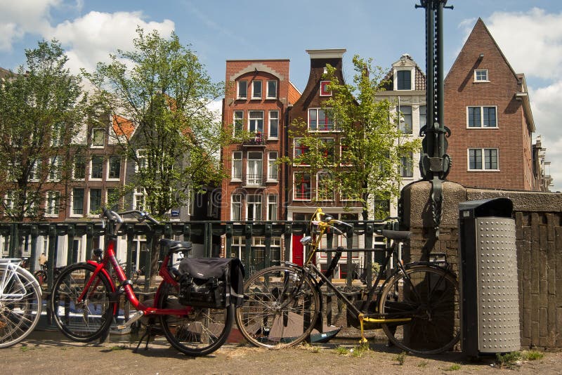 Amsterdam bikes at sidewalk with houses on background