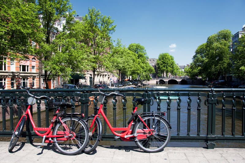 A classical Amsterdam canal with two red bicycles parked. A classical Amsterdam canal with two red bicycles parked