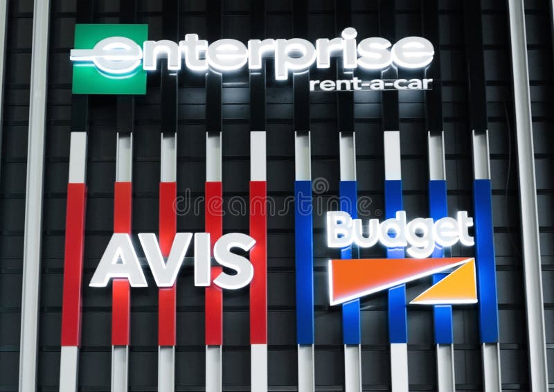 AMSTERDAM, NEDERLAND - JULI 18, 2018: Avis Enterprice Budget-het aanplakbord van de huurauto op staalomheining in luchthaven royalty-vrije stock foto's AMSTERDAM, NEDERLAND - JULI 18, 2018: Avis Enterprice Budget-het aanplakbord van de huurauto op staalomheining in luchthaven royalty-vrije stock foto's