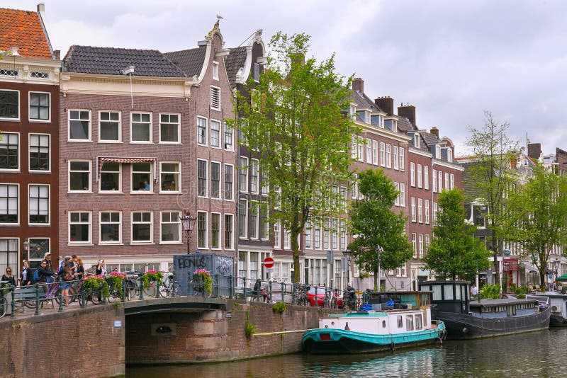 AMSTERDAM, NETHERLANDS - JUNE 25, 2017: Old buildings near the one of the water canals.