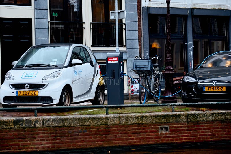 Amsterdam, Países Bajos - 22 de noviembre de 2017: Fuente de alimentación para la carga del coche eléctrico Estación de carga del fotos de archivo Amsterdam, Países Bajos - 22 de noviembre de 2017: Fuente de alimentación para la carga del coche eléctrico Estación de carga del fotos de archivo