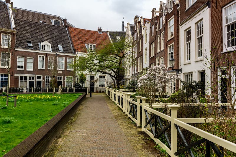 AMSTERDAM SOM ÄR NEDERLÄNDSK - APRIL 9, 2018: Begijnhof är en av de äldsta inre domstolarna i staden av Amsterdam En grupp av his royaltyfria foton AMSTERDAM SOM ÄR NEDERLÄNDSK - APRIL 9, 2018: Begijnhof är en av de äldsta inre domstolarna i staden av Amsterdam En grupp av his royaltyfria foton