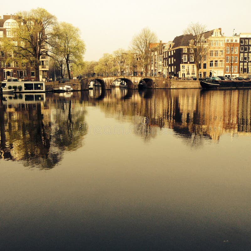 Amsterdam-/THENEDERLÄNDERNA: En typisk sikt av den Amstel kanalen med gamla herrgårdar i mitten av Amsterdam, net royaltyfria bilder