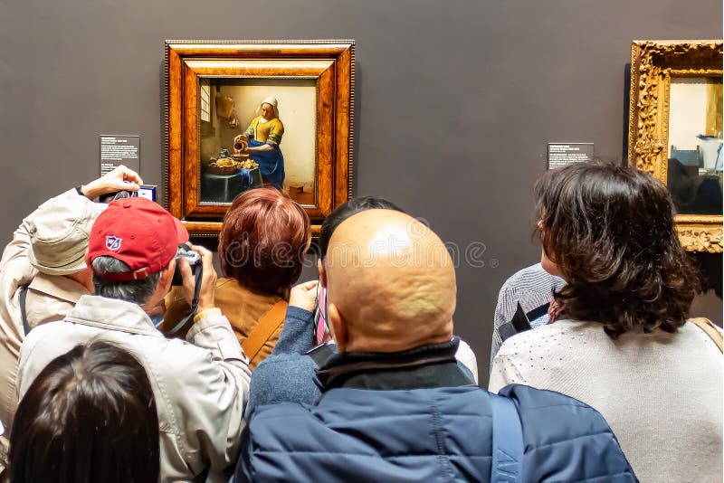 Amsterdam-visitantes que miran a la lechera de la pintura de Johannes Vermeer fotografía de archivo Amsterdam-visitantes que miran a la lechera de la pintura de Johannes Vermeer fotografía de archivo