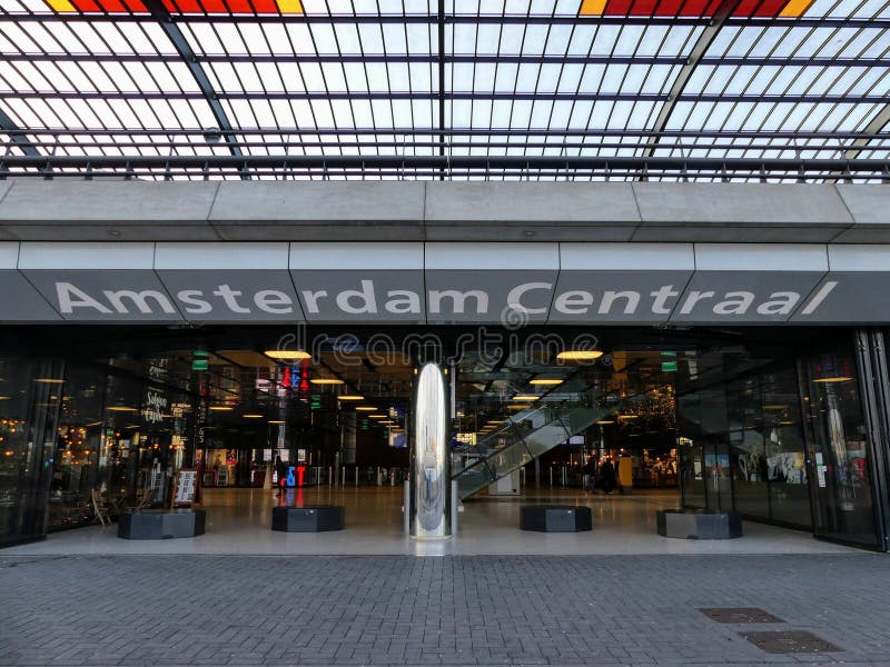 Amsterdão, Países Baixos - 12 de dezembro de 2028: Estação central de Amsterdão, uma ideia da entrada lateral portuária e seu sig imagens de stock royalty free Amsterdão, Países Baixos - 12 de dezembro de 2028: Estação central de Amsterdão, uma ideia da entrada lateral portuária e seu sig imagens de stock royalty free
