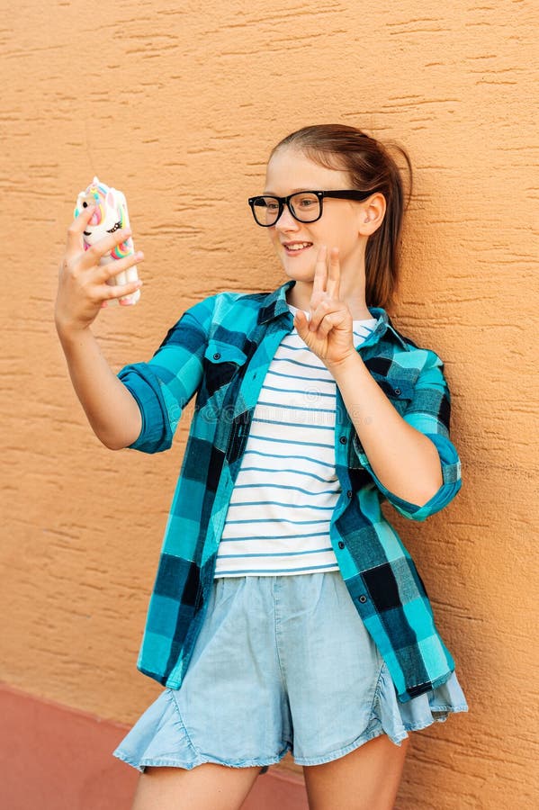 Amusante fille préadolescente prenant un selfie avec un téléphone photographie stock