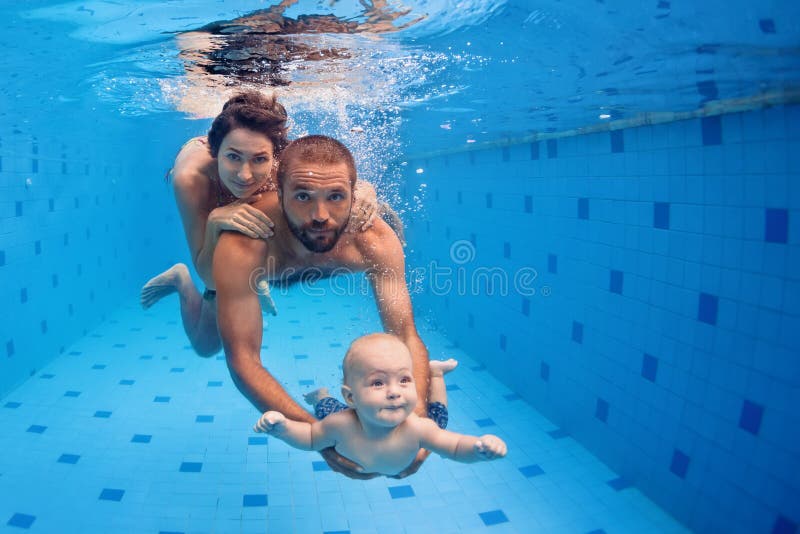 Amusement de famille dans la piscine - mère, père, piqué de bébé sous-marin photo libre de droits
