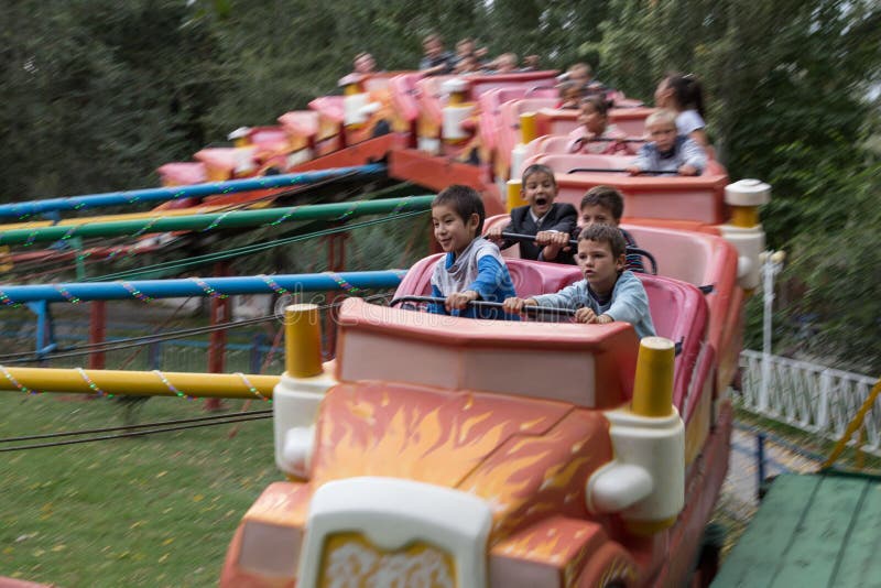 Bishkek, Kyrgyzstan - September 30, 2014: Kyrgyz children having fun in an amusement park. Bishkek, Kyrgyzstan - September 30, 2014: Kyrgyz children having fun in an amusement park.