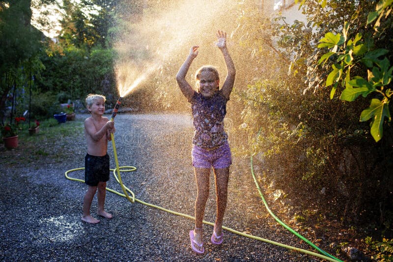 Amusez-vous avec l'eau vaporisez des vacances d'enfance heureuses image libre de droits
