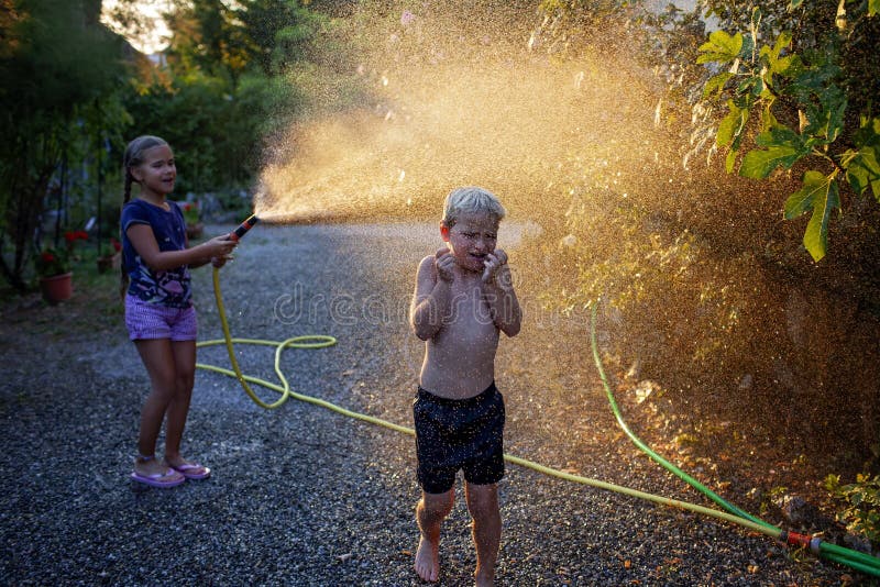 Amusez-vous avec l'eau vaporisez des vacances d'enfance heureuses photo stock
