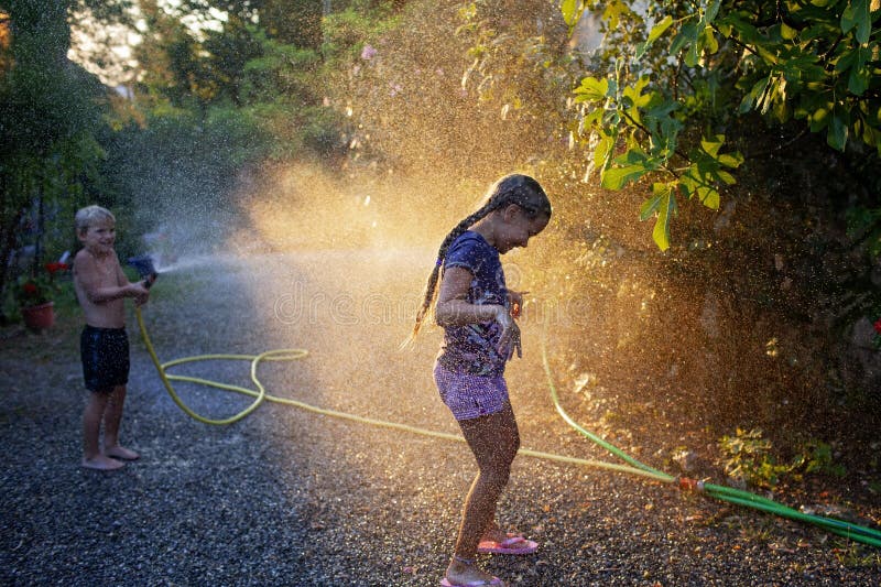 Amusez-vous avec l'eau vaporisez des vacances d'enfance heureuses photo libre de droits
