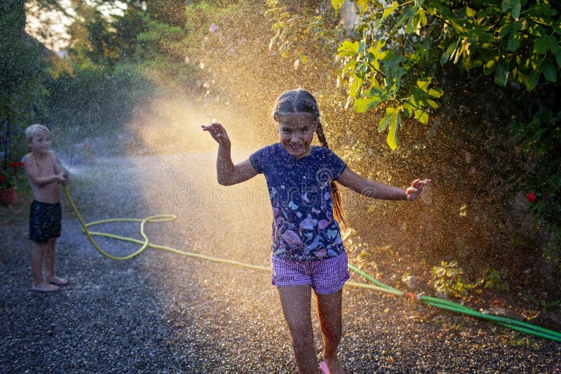 Amusez-vous avec l'eau vaporisez des vacances d'enfance heureuses images stock