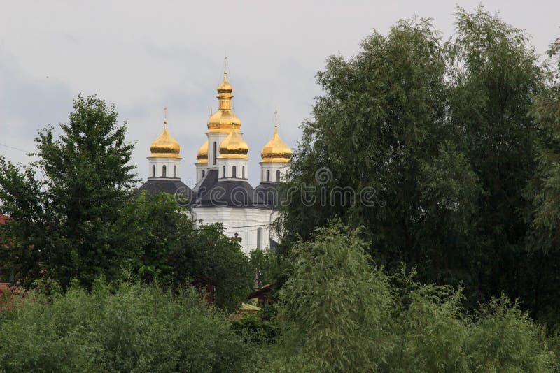 Aménagez en parc avec l'église du ` s de Catherine, le ciel nuageux, le soleil et les arbres sans feuilles, début mars, Chernigiv images stock Aménagez en parc avec l'église du ` s de Catherine, le ciel nuageux, le soleil et les arbres sans feuilles, début mars, Chernigiv images stock