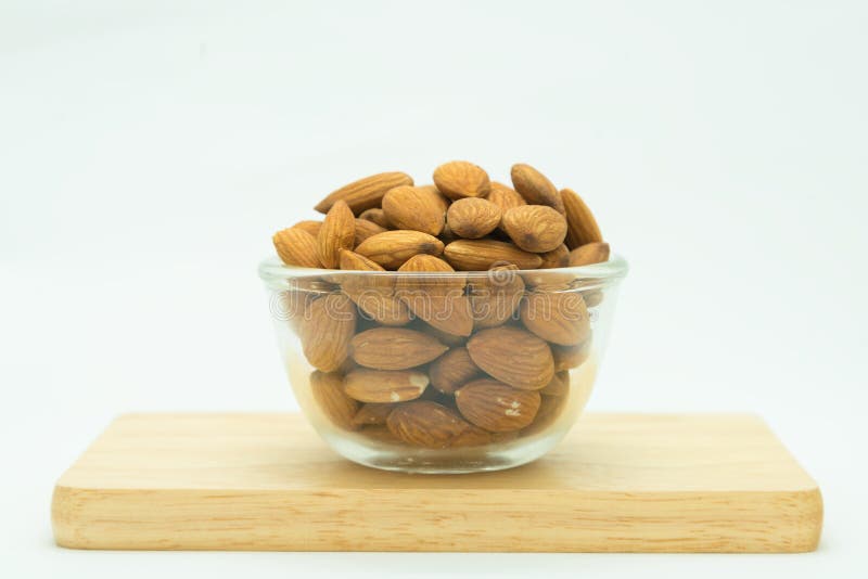 Amêndoa de Brown no copo de vidro, no branco fotos de stock royalty free