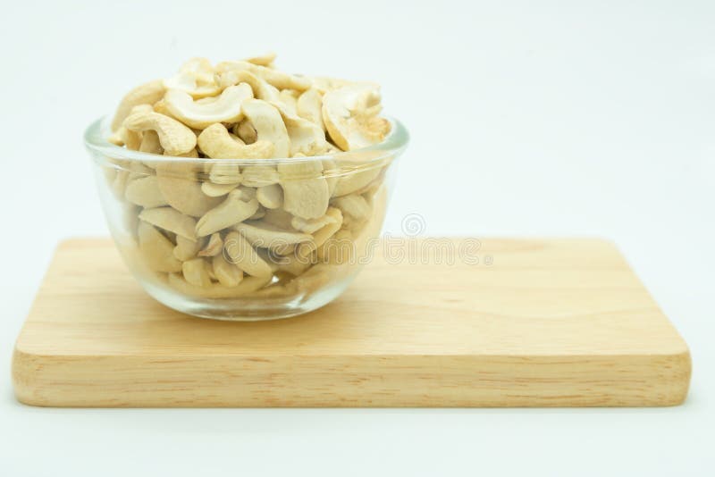 Amêndoas na bacia de vidro com placa de madeira foto de stock royalty free