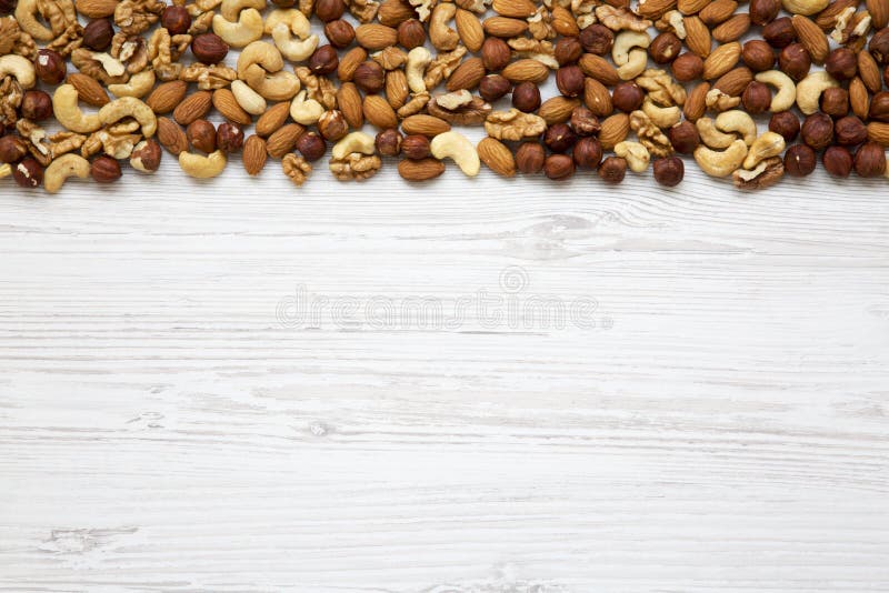 Anacardio matto misto assortito, nocciole, noci, mandorle su fondo di legno bianco, vista superiore Da sopra immagini stock Anacardio matto misto assortito, nocciole, noci, mandorle su fondo di legno bianco, vista superiore Da sopra immagini stock