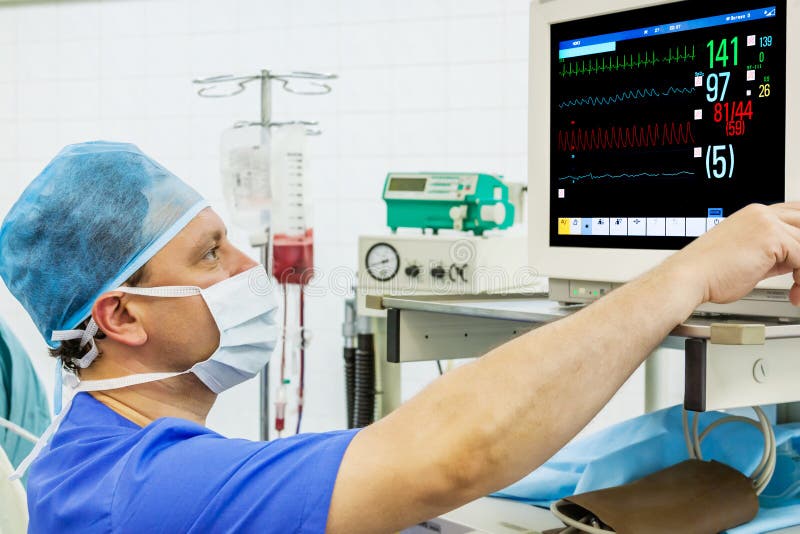 Anaesthesiologist de sexo masculino experimentado en el monitor fotografía de archivo libre de regalías Anaesthesiologist de sexo masculino experimentado en el monitor fotografía de archivo libre de regalías