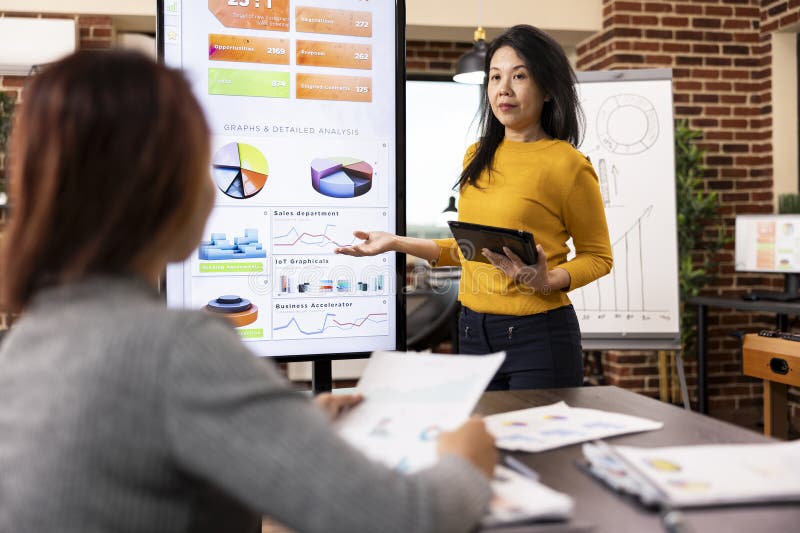 Analyst pointing at screen in meeting stock photography