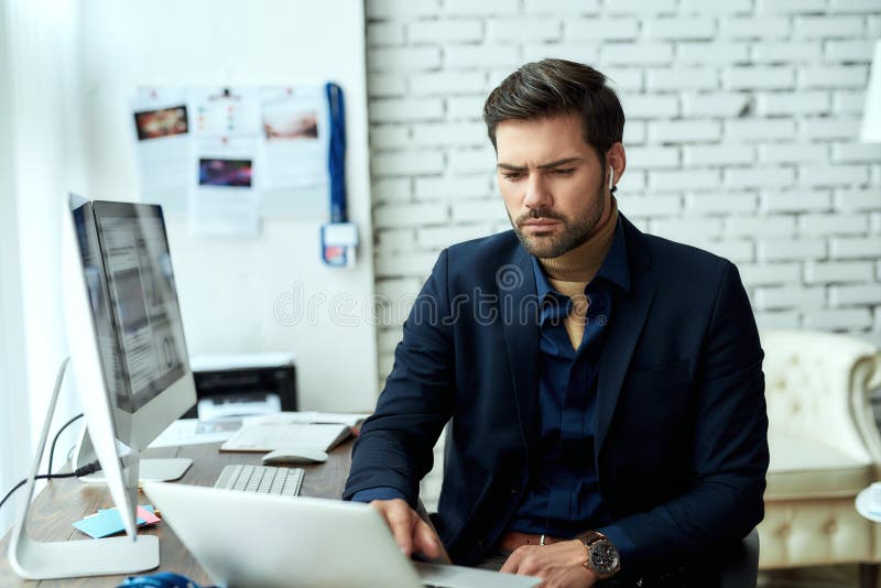 Analyzing statistical data. Young focused businessman, financial analyst or sales manager sitting at his workplace in stock image