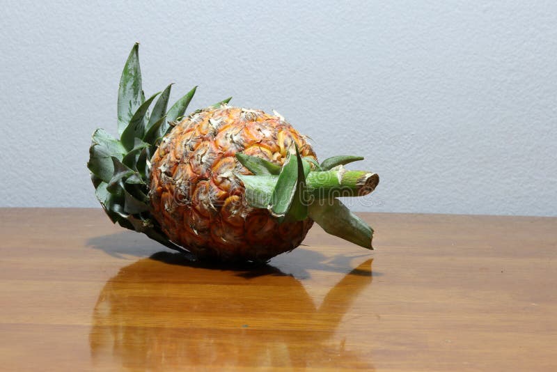 Ananas gezet op de houten lijst E stock afbeelding Ananas gezet op de houten lijst E stock afbeelding