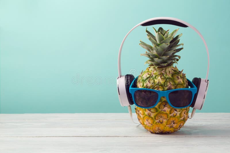 Ananas z hełmofonami i okularami przeciwsłonecznymi na drewnianym stole nad nowym tłem Tropikalny wakacje i plaży przyjęcie fotografia royalty free Ananas z hełmofonami i okularami przeciwsłonecznymi na drewnianym stole nad nowym tłem Tropikalny wakacje i plaży przyjęcie fotografia royalty free